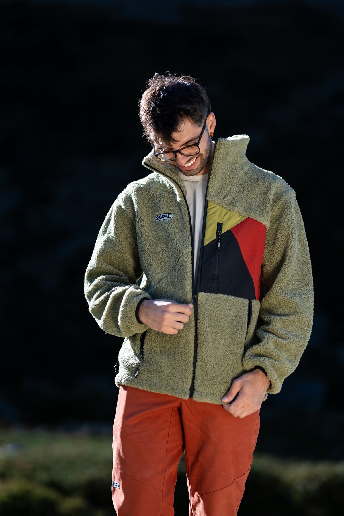 FW26-100 Yeti 2.0 Greenwich + Pirenei Rust (uomo serale che chiude la zip)