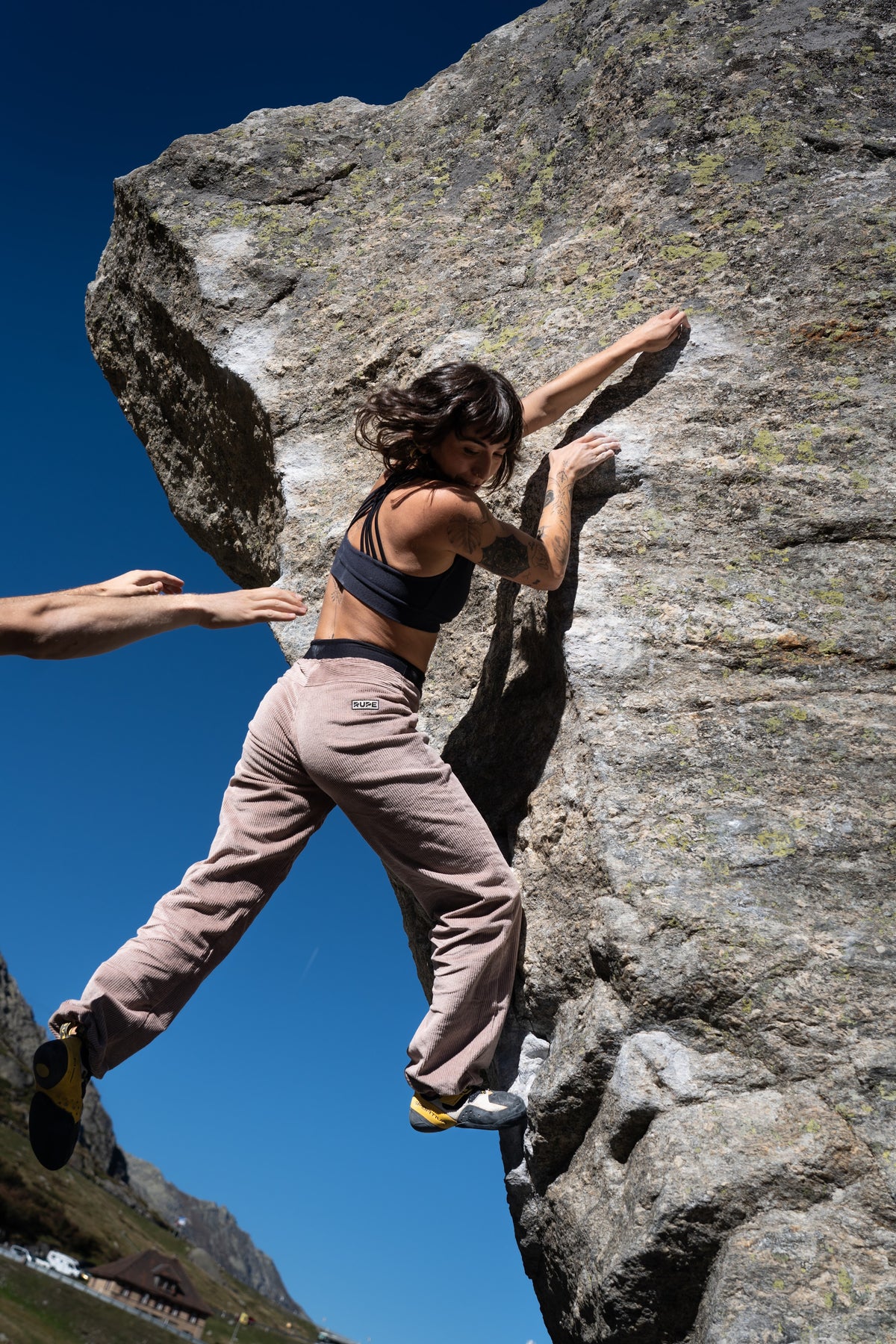 FW26-072 Core Navy + RILA Taupe (donna in arrampicata, spaccata dinamica, cielo blu)